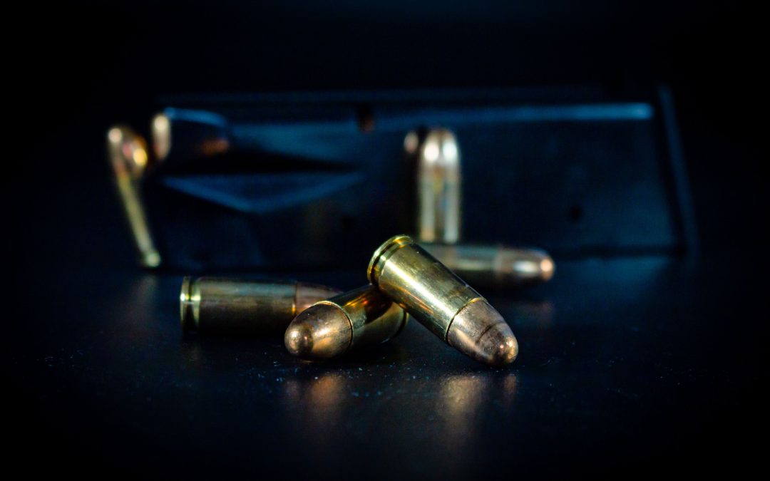 bullets sitting in front of firearm with dark background - Virginia assault weapons ban